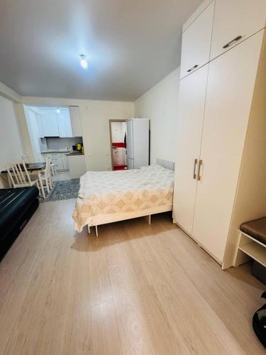 a bedroom with a bed and a kitchen with a refrigerator at 1apartment on First Line-Bosteri in Bosteri