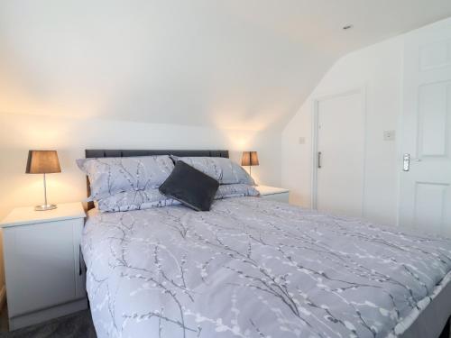 ein Schlafzimmer mit einem Bett mit blauer Bettdecke und zwei Lampen in der Unterkunft Frome View in Wareham