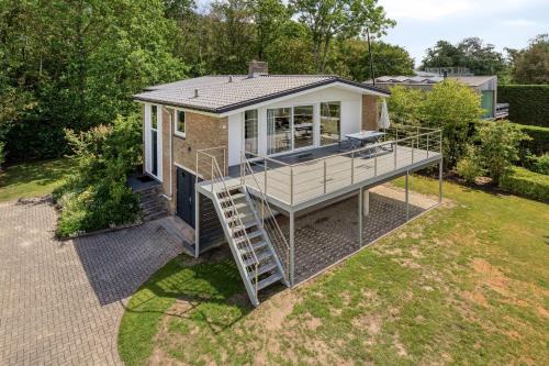 a tiny house with a deck and a ladder at Holidayhouse De Schotsman in Kamperland