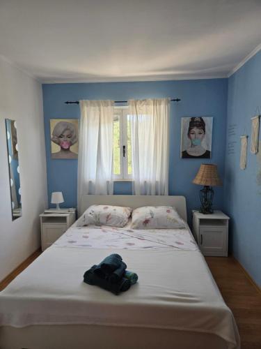 a bedroom with a large bed with blue walls at Babić Rituals apartments in Makarska