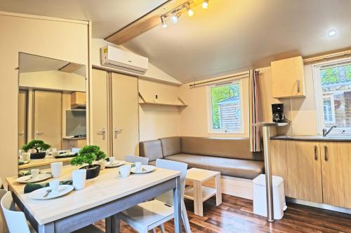a kitchen and living room with a table and a couch at Clairière AC - Petfriendly Piscine in Saint-Chéron