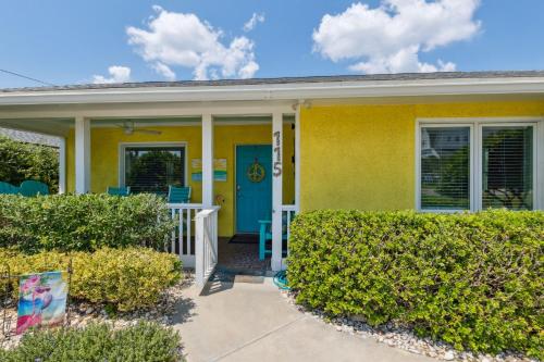 a yellow house with a blue door and bushes at 115 South Fletcher in Fernandina Beach