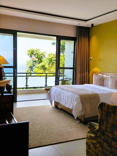 a bedroom with a large bed and a balcony at RUBONA HILL Lodge in Gisenyi