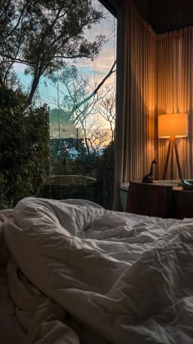 an unmade bed in a bedroom with a window at Cabanas Rancho Alcântara in Treviso
