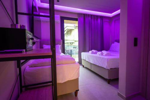 a purple room with two beds and a tv at Troy Seaside in Paralia Katerinis