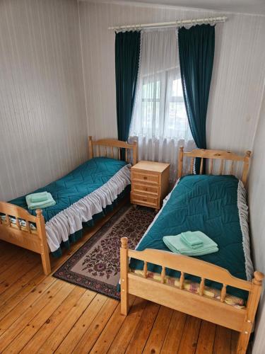 two twin beds in a room with a window at Cousy Center House in Šiauliai