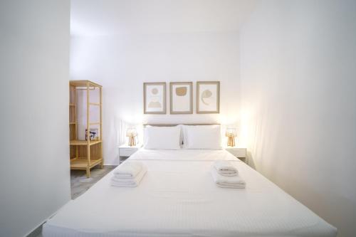 a bedroom with a white bed with two towels on it at Veniro Luxury Apartments in Moírai