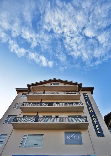 a tall tan building with a blue sky in the background at Trillium Hotel by Stay Sphere in Srinagar