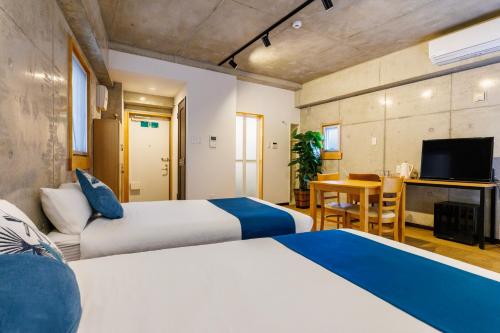 a hotel room with two beds and a television at Kokusai Street Garden Hotel in Naha
