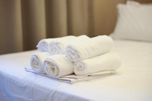 a pile of towels sitting on top of a bed at Troy Seaside in Paralia Katerinis