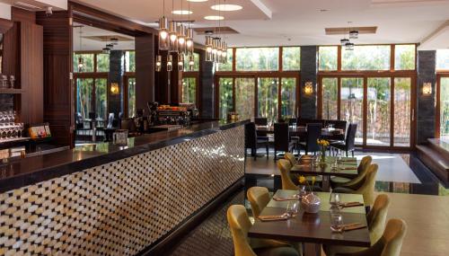 a restaurant with tables and chairs and a bar at Duna Garden Hotel in Budapest