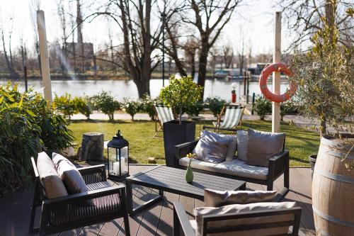 a patio with chairs and a table with pillows at Duna Garden Hotel in Budapest
