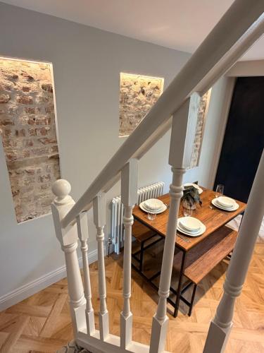 a dining room and stairs with a table and chairs at St Johns Central Canterbury Cottage in Canterbury