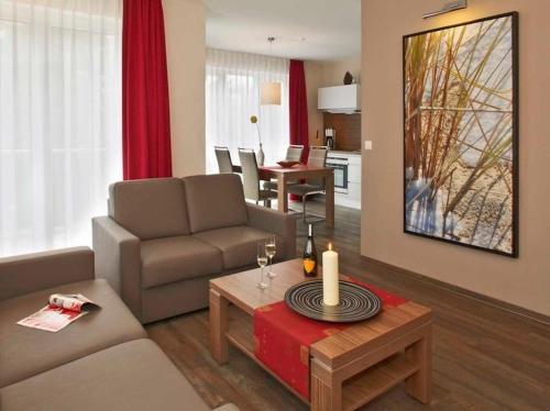 a living room with a couch and a table at Dünenhaus Aurell, App 4 mit Sauna in Heringsdorf
