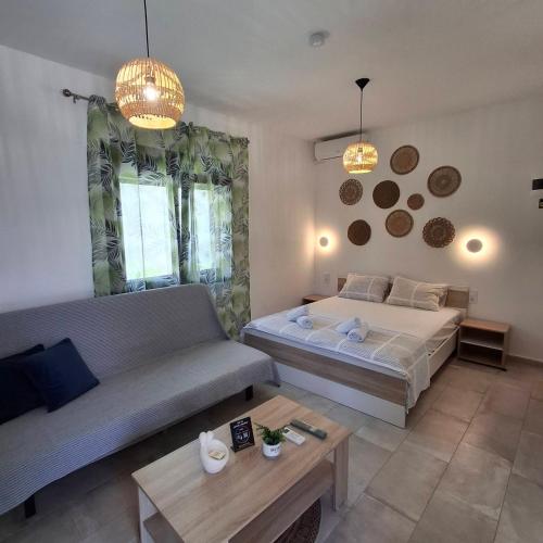 a living room with a bed and a couch at Sky Rooms in Nea Kallikrateia