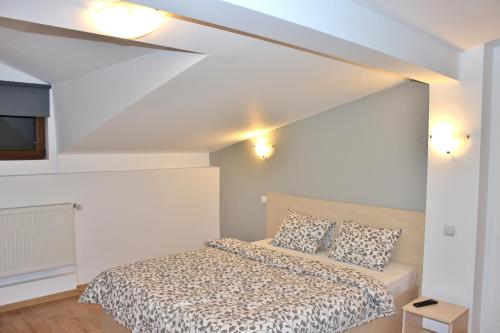 a bedroom with a bed in a white room at Central Guesthouse in Bucharest