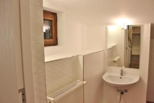 a white bathroom with a sink and a mirror at Central Guesthouse in Bucharest
