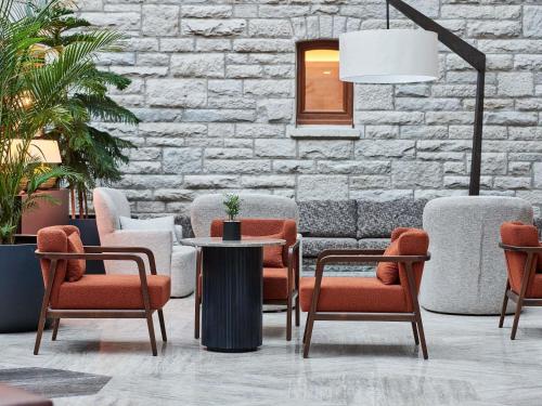 a lobby with chairs and a table and a stone wall at Swissotel Uludag Bursa in Bursa