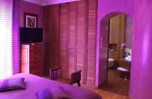 a purple room with a bedroom with a bed and a tv at B&B Val D'azur in Carqueiranne