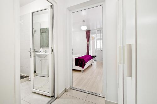 a bathroom with a glass door leading to a bedroom at Danube Residence in Galaţi