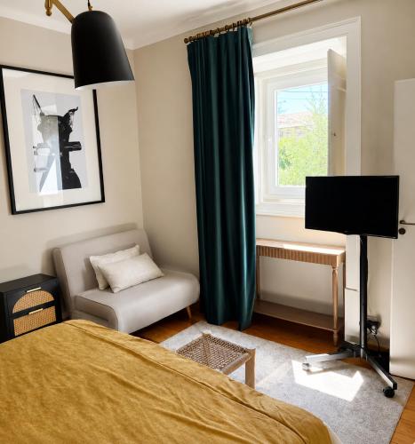 a bedroom with a bed and a chair and a window at Casa da Loja in Marinha Grande