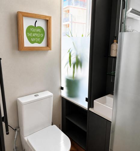 a bathroom with a toilet and a plant in a window at Casa da Loja in Marinha Grande