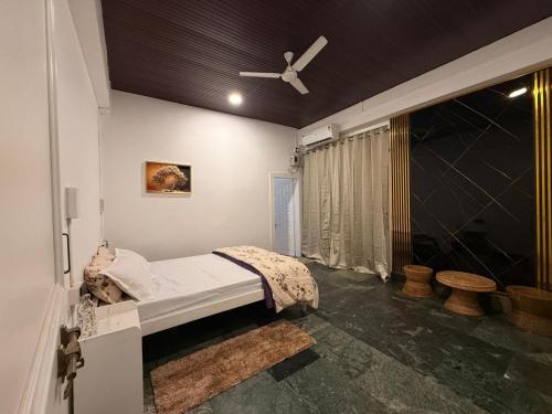 a bedroom with a bed and a ceiling fan at Lighthouse Villa Homestay in Dimapur