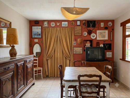 a dining room with a table and a television at Caporizon - La Solognote in Bracieux