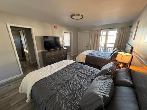 a hotel room with two beds and a couch at Empire Extended Stay in Webster