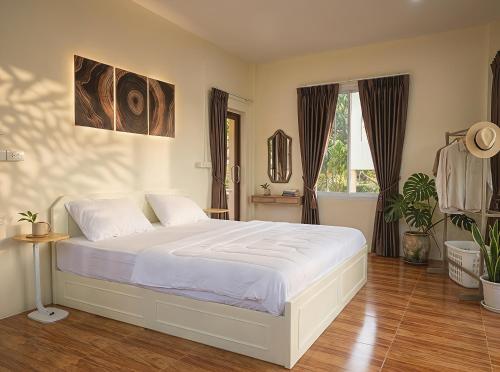 a bedroom with a large white bed in it at Casa Srithanu in Ko Phangan