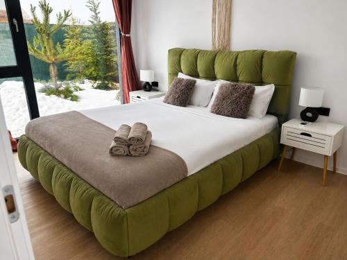 a bedroom with a large bed with a green headboard at Casa en Sol - 5 min walk to Therme Balotesti in Baloteşti