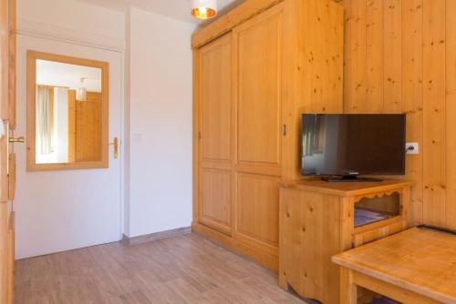 a living room with a television on a wooden cabinet at Résidence La Grande Cordée - Combloux in Combloux