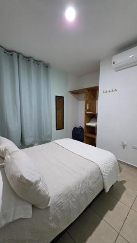 a bedroom with a large white bed with blue curtains at Casa León Cerca del Aeropuerto Internacional y Parques Industriales, Facturamos in Monterrey