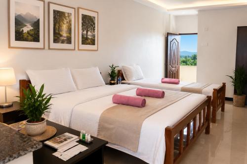 a bedroom with two beds and a table and a room at THE MOUNT VIEW CASTLE HOTELS and RESORTS in Tenkāsi