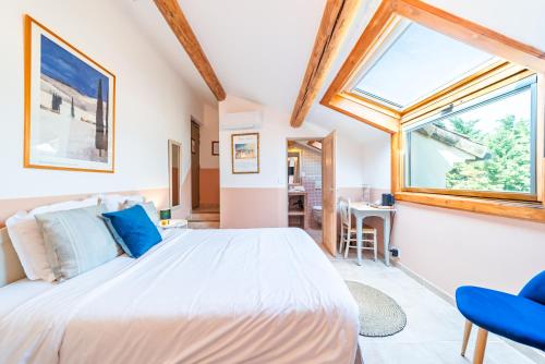 a bedroom with a large bed and a window at Le Domaine des Grès Luberon - Hôtel - Restaurant Sous les Platanes - Restaurant 901 côté piscine in Lagnes