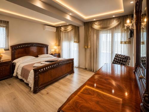a bedroom with a large bed and a wooden table at GF Luxury Villa with indoor pool -Afytos in Afitos
