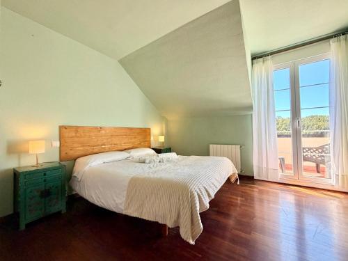 a bedroom with a bed and a large window at Casa Mirador del Pas - Monabri in Boó de Piélagos