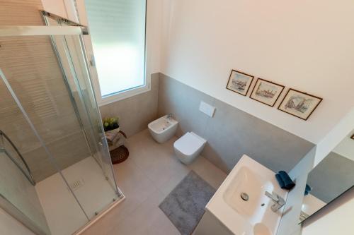 a bathroom with a shower and a toilet and a sink at In Riva in Cavallino-Treporti