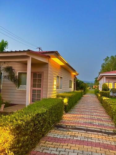 a house with a brick road in front of it at Corbett VEDA INN in Rāmnagar