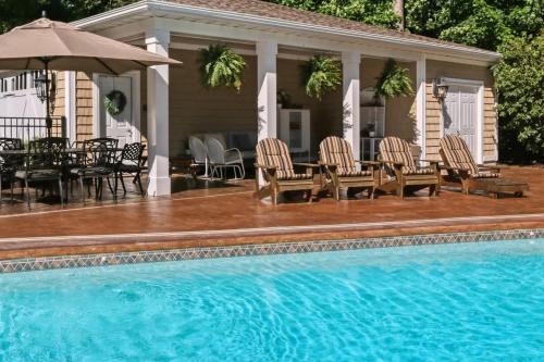 a pool with chairs and a table and an umbrella at Inn Like a Lamb in South Haven