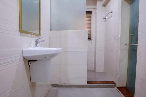 ein weißes Badezimmer mit Waschbecken und Dusche in der Unterkunft Romeneo Grand Royal Hotel in Lagos