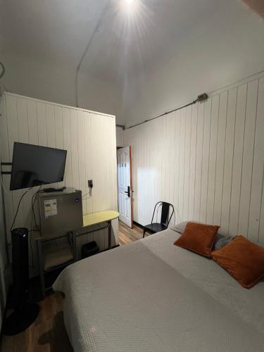a bedroom with a bed and a television in it at VOY Hostales - Poniente in Viña del Mar