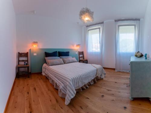 a bedroom with a large bed and two windows at In Riva in Cavallino-Treporti