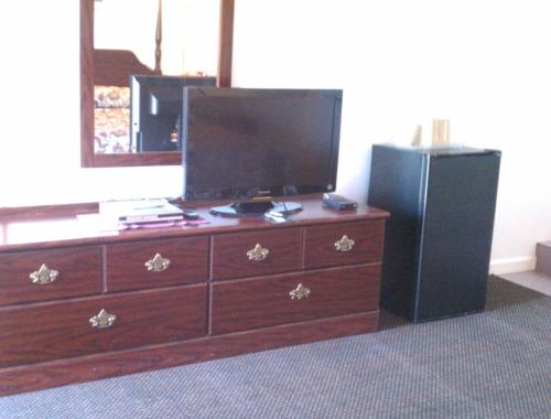a dresser with a television and a black refrigerator at Valley Motel Pittsburgh in Harmarville