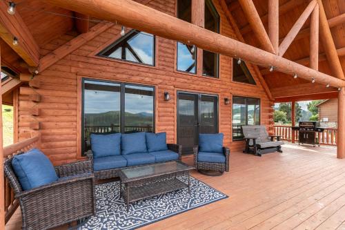 a porch of a cabin with blue furniture and windows at Chasing Clouds Cabin in Todd