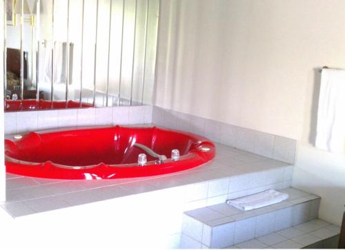 a red tub in a bathroom with a white counter at Valley Motel Pittsburgh in Harmarville