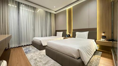 a hotel room with two beds and a desk at The Villas Hotel in Pleiku