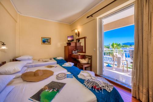 zwei Betten in einem Zimmer mit großem Fenster in der Unterkunft Sunset Hotel in Korfu-Stadt