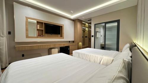 a hotel room with two beds and a television at The Villas Hotel in Pleiku