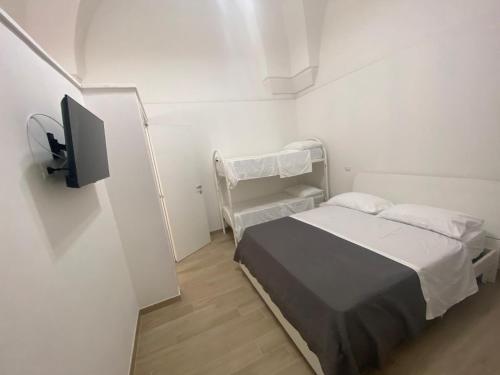 a small white room with a bed and a tv at Leonardo in Veglie